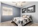 Cozy bedroom featuring a ceiling fan, natural light, and neutral decor at 16118 W Morning Glory St, Goodyear, AZ 85338