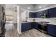 Kitchen with stainless steel appliances, stylish blue cabinets, and wood-look flooring at 16118 W Morning Glory St, Goodyear, AZ 85338