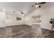 Bright open living room with a sliding glass door, ceiling fan, and wood-look floors at 16118 W Morning Glory St, Goodyear, AZ 85338