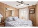 This bedroom features panel walls, a ceiling fan, and a window, creating a comfortable living space at 17200 W Bell Rd # 2189, Surprise, AZ 85374