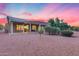 Expansive backyard featuring desert landscaping, mature trees, and covered patio at 17911 N Adobe Mesa Ct, Surprise, AZ 85374