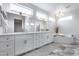 Spacious bathroom with double vanity, sleek mirrors, modern lighting, and a luxurious soaking tub at 17911 N Adobe Mesa Ct, Surprise, AZ 85374