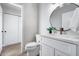 Bathroom with a round mirror, white vanity, gold fixtures, and an open doorway to the shower at 17911 N Adobe Mesa Ct, Surprise, AZ 85374