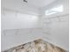 Walk-in closet with adjustable shelving and a unique tile floor with a window for natural light at 17911 N Adobe Mesa Ct, Surprise, AZ 85374