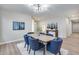 Inviting dining area with modern table, blue chairs, and view of entryway, blending style and comfort at 17911 N Adobe Mesa Ct, Surprise, AZ 85374