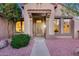 Inviting front entrance featuring a covered porch, lush landscaping, and modern architectural details at 17911 N Adobe Mesa Ct, Surprise, AZ 85374