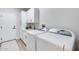 Bright laundry room featuring white cabinets, a sink, and modern washer and dryer appliances at 17911 N Adobe Mesa Ct, Surprise, AZ 85374