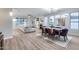 Spacious living room with wood flooring, fireplace, and ample natural light from large windows at 17911 N Adobe Mesa Ct, Surprise, AZ 85374