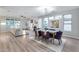 Open-concept living and dining area with wood floors, natural light, and contemporary furniture at 17911 N Adobe Mesa Ct, Surprise, AZ 85374