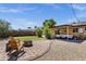Large backyard with a mix of rock and grassy area, showcasing a patio, BBQ area, and fire pit at 2118 W Cactus Wren Dr, Phoenix, AZ 85021