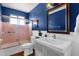 Stylish bathroom featuring blue accent wall, shower with glass door, and sink with updated fixtures at 2118 W Cactus Wren Dr, Phoenix, AZ 85021