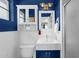 Stylish blue bathroom with white wainscoting, offering a unique vanity, mirror, and modern toilet at 2118 W Cactus Wren Dr, Phoenix, AZ 85021