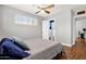 Comfortable bedroom with ceiling fan, window, and doorway leading to connected bathroom and office at 2118 W Cactus Wren Dr, Phoenix, AZ 85021