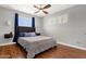 Cozy bedroom with ceiling fan, wood floors, a queen-size bed and natural light from the window at 2118 W Cactus Wren Dr, Phoenix, AZ 85021