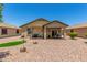Expansive backyard featuring gravel landscaping, a covered patio, and a built-in barbecue area at 22403 W Harrison St, Buckeye, AZ 85326
