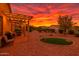 Expansive backyard featuring a covered patio, seating area, BBQ, and artificial turf in a desert landscape at 22403 W Harrison St, Buckeye, AZ 85326