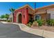 Beautiful clubhouse featuring a red stucco accent wall and a tile roof with a manicured landscape at 22403 W Harrison St, Buckeye, AZ 85326