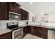 Well-equipped kitchen with stainless steel appliances, dark wood cabinets, and granite countertops at 22403 W Harrison St, Buckeye, AZ 85326