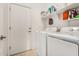 Efficient laundry room with appliances, storage shelves, and a convenient exterior access door at 22403 W Harrison St, Buckeye, AZ 85326