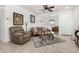 Comfortable living room with neutral tones, tile flooring, ceiling fan, and traditional furnishings at 22403 W Harrison St, Buckeye, AZ 85326