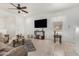 Bright living room features tile flooring, a ceiling fan, television, and comfortable seating at 22403 W Harrison St, Buckeye, AZ 85326