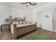 Comfortable main bedroom with plush carpet, decorative headboard, ceiling fan and side table at 22403 W Harrison St, Buckeye, AZ 85326