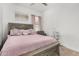 Comfortable main bedroom featuring a decorative headboard, soft pink comforter, and neutral colored walls at 22403 W Harrison St, Buckeye, AZ 85326