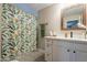 Bright bathroom with modern vanity, decorative mirror and shower with tropical-themed curtain at 2520 N 15Th St, Phoenix, AZ 85006