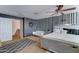 Charming bedroom with striped accent wall, a love seat and decorative ceiling fan at 25519 W Crown King Rd, Buckeye, AZ 85326