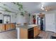 Open kitchen with center island, tile floors, and stainless steel appliances, connected to dining area at 25519 W Crown King Rd, Buckeye, AZ 85326