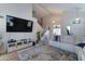 Open living space with stairs, entertainment center, vaulted ceilings, and comfortable white sofa at 25519 W Crown King Rd, Buckeye, AZ 85326