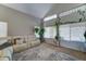 Bright living room with vaulted ceilings, large windows, a comfortable sofa, and neutral decor at 25519 W Crown King Rd, Buckeye, AZ 85326