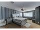 Spacious main bedroom with striped accent wall, plush bedding, and modern furnishings at 25519 W Crown King Rd, Buckeye, AZ 85326