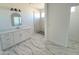 Bright bathroom featuring marble floors and a modern vanity with a marble countertop and a walk-in shower at 28151 N Faded Creek Dr, Florence, AZ 85132