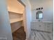 Bathroom featuring double vanity, marble floors and walk-in closet with carpeting at 28151 N Faded Creek Dr, Florence, AZ 85132