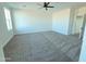 Spacious bedroom with plush gray carpet, a ceiling fan, and bright natural light at 28151 N Faded Creek Dr, Florence, AZ 85132