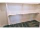 Walk-in closet with white shelving and gray carpet, providing ample storage space at 28151 N Faded Creek Dr, Florence, AZ 85132