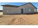 Newly built home featuring a gray exterior, windows, and a dark-colored front door at 28151 N Faded Creek Dr, Florence, AZ 85132