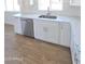 Close-up of the kitchen sink, dishwasher, and cabinets, with tile backsplash and quartz countertops at 28151 N Faded Creek Dr, Florence, AZ 85132