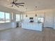Open-concept kitchen with white cabinets, stainless steel appliances and a large island at 28151 N Faded Creek Dr, Florence, AZ 85132