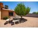 Landscaped backyard featuring desert landscaping, a covered patio, and mature trees for privacy and shade at 3507 W Oakland St, Chandler, AZ 85226