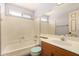 Bright bathroom featuring a tub with shower and a single sink vanity with a large mirror at 3507 W Oakland St, Chandler, AZ 85226