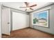 Bedroom featuring a large window with natural light, carpet, ceiling fan, and a closet at 3507 W Oakland St, Chandler, AZ 85226