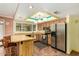 Well-equipped kitchen with a breakfast bar, stainless steel refrigerator, and modern lighting fixtures at 3507 W Oakland St, Chandler, AZ 85226