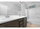 Bathroom with dual sinks, dark cabinetry and shower-tub combo at 37460 W Giallo Ln, Maricopa, AZ 85138