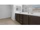 Bathroom with dual sinks, dark cabinetry and chrome hardware at 37460 W Giallo Ln, Maricopa, AZ 85138
