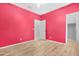 Bedroom with wood-look floors, a ceiling fan and white door to ensuite bathroom at 37460 W Giallo Ln, Maricopa, AZ 85138