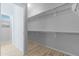 Walk-in closet with wood-look floors and rod for hanging clothes at 37460 W Giallo Ln, Maricopa, AZ 85138