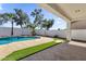 Inviting backyard featuring a sparkling blue pool, a stone deck and green turf at 389 W Fairway Pl, Chandler, AZ 85225