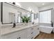 Elegant bathroom with dual sinks, quartz countertop, and a separate soaking tub at 389 W Fairway Pl, Chandler, AZ 85225